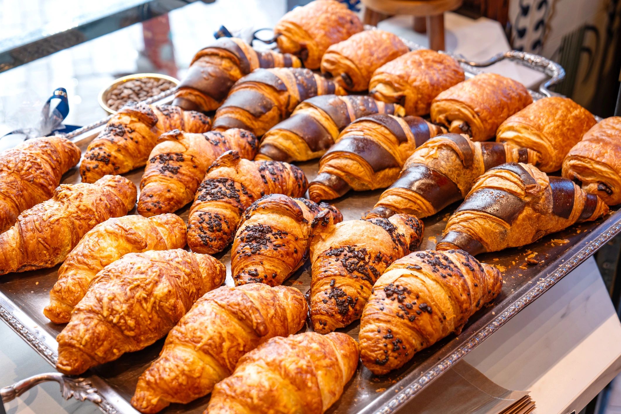 Variety of freshly made French croissants on a silver tray